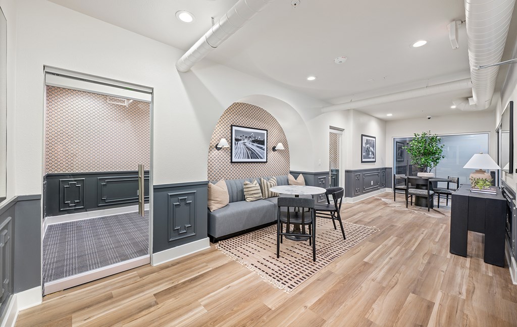 A modern living room with a grey couch and a wooden floor.