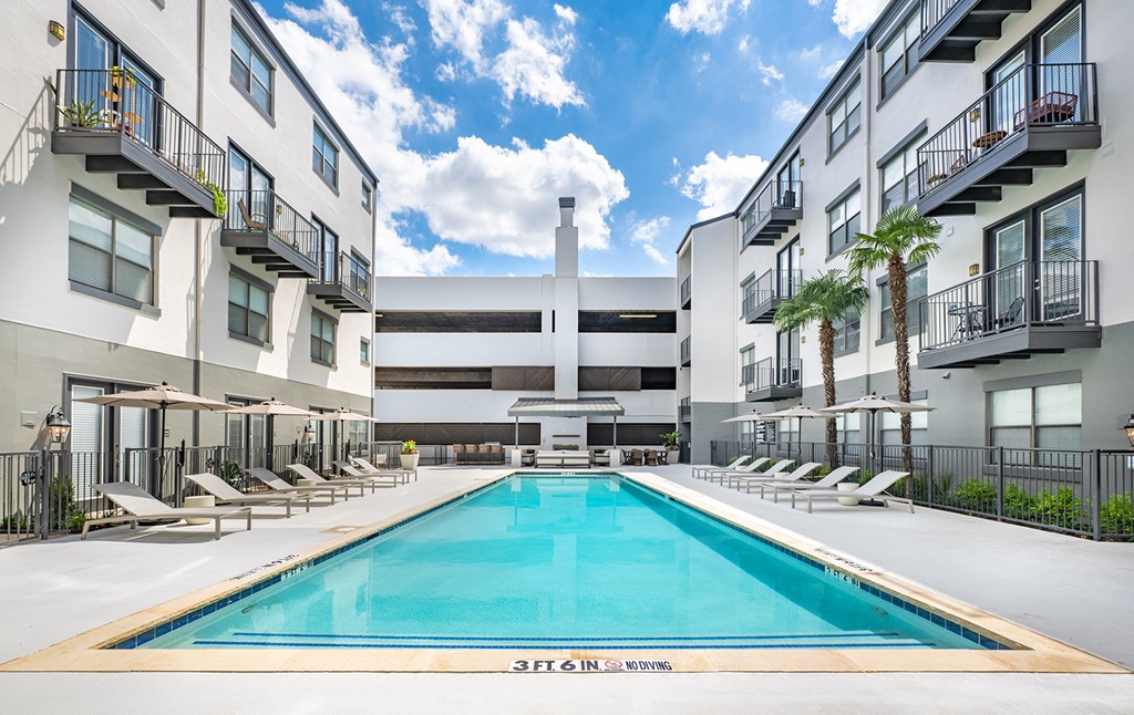 A swimming pool in the middle of a courtyard surrounded by buildings.