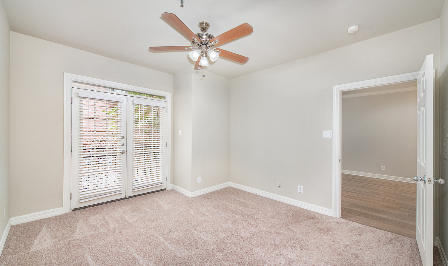 a living room with a ceiling fan and a door to a closet