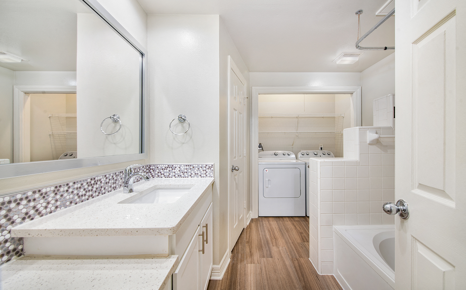 a bathroom with a sink and a mirror and a laundry room