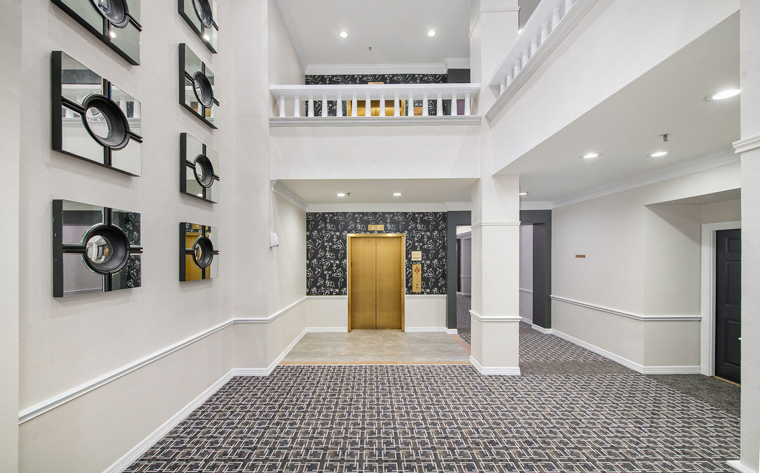 a large hall with a wooden door and a carpeted floor