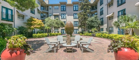 a courtyard with a table and chairs in front of an apartment building