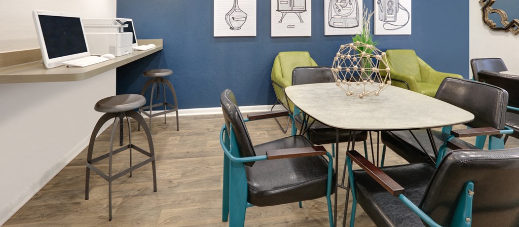 a dining room with a table and chairs and a computer