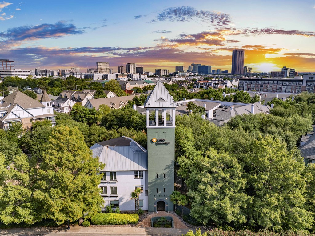 A clock tower stands in the middle of a lush green park.