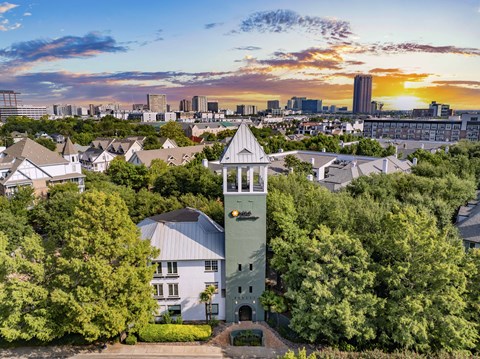 A clock tower stands in the middle of a lush green park.