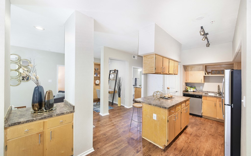 A kitchen with wooden cabinets and a black refrigerator.