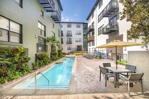 A small pool surrounded by a table and chairs.
