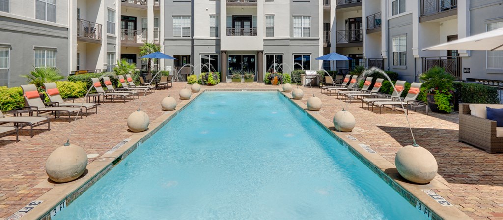 a large swimming pool in front of an apartment building