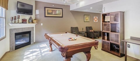 a living room with a pool table and a fireplace