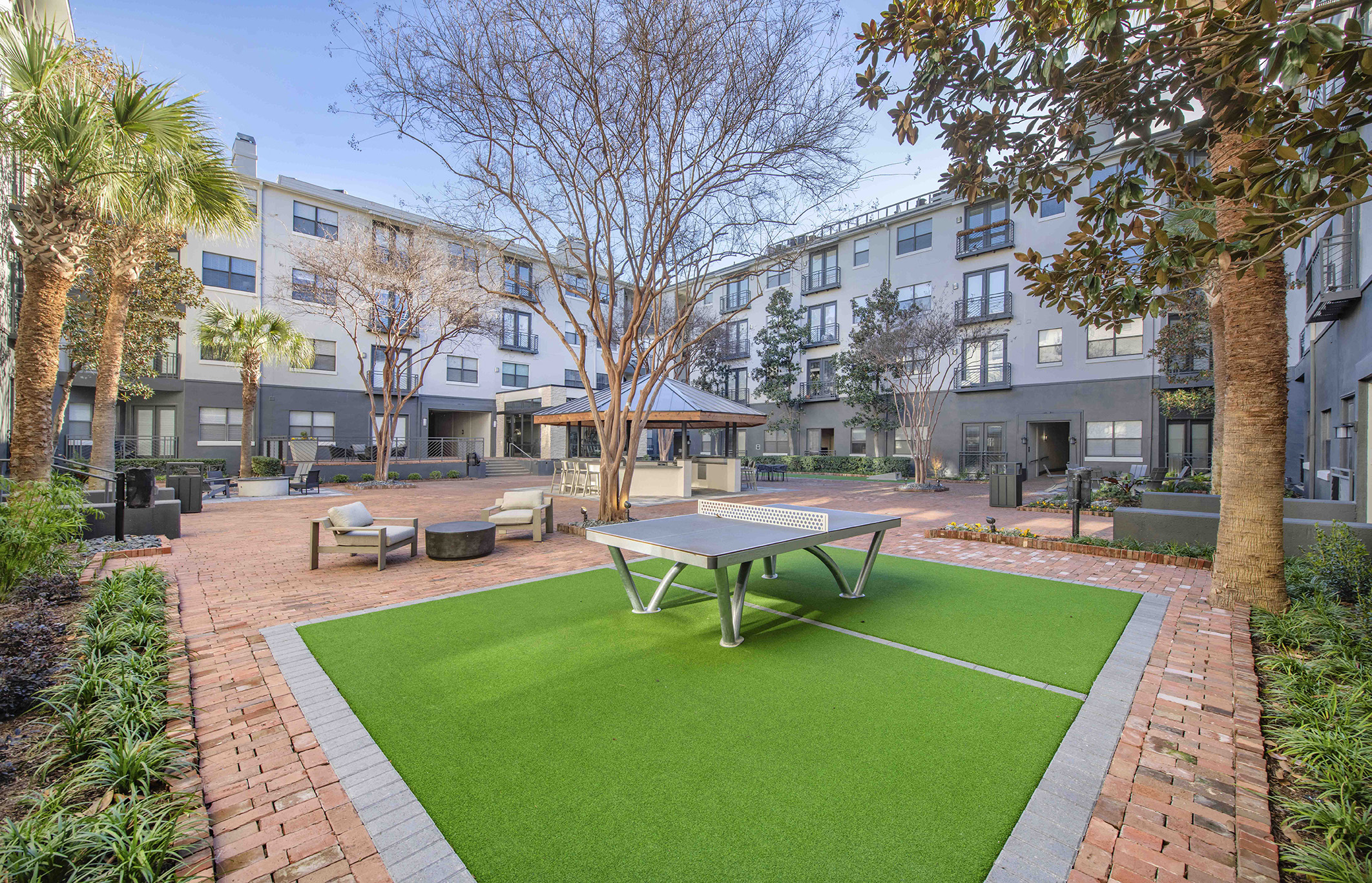 a courtyard with a ping pong table and a gazebo