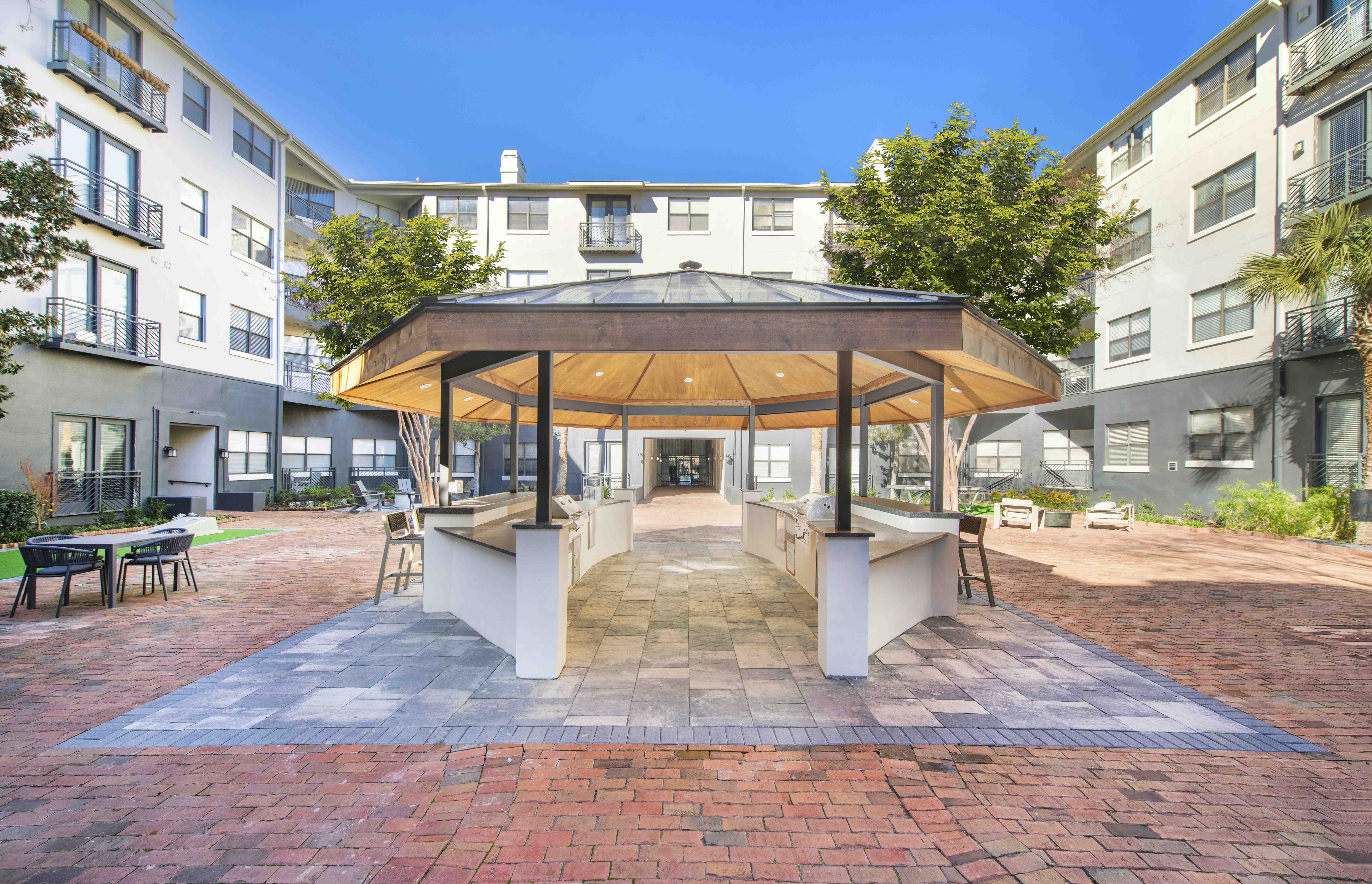 an outdoor patio area with a gazebo at an apartment building
