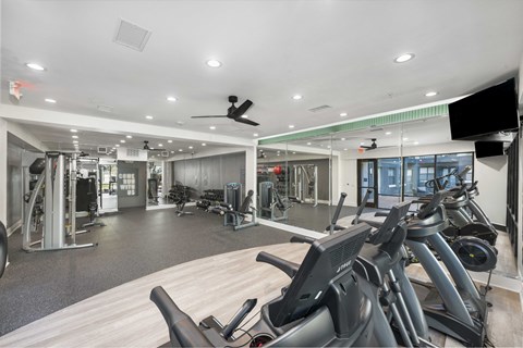A gym with treadmills, weights, and other exercise equipment.