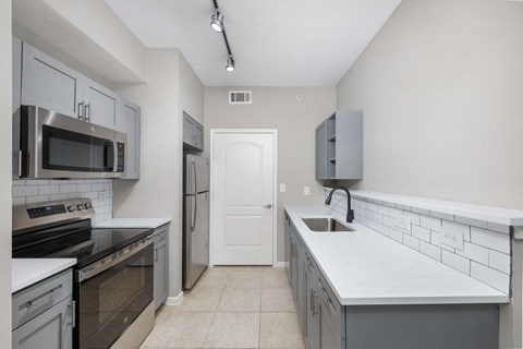 A kitchen with a white door and a white counter.