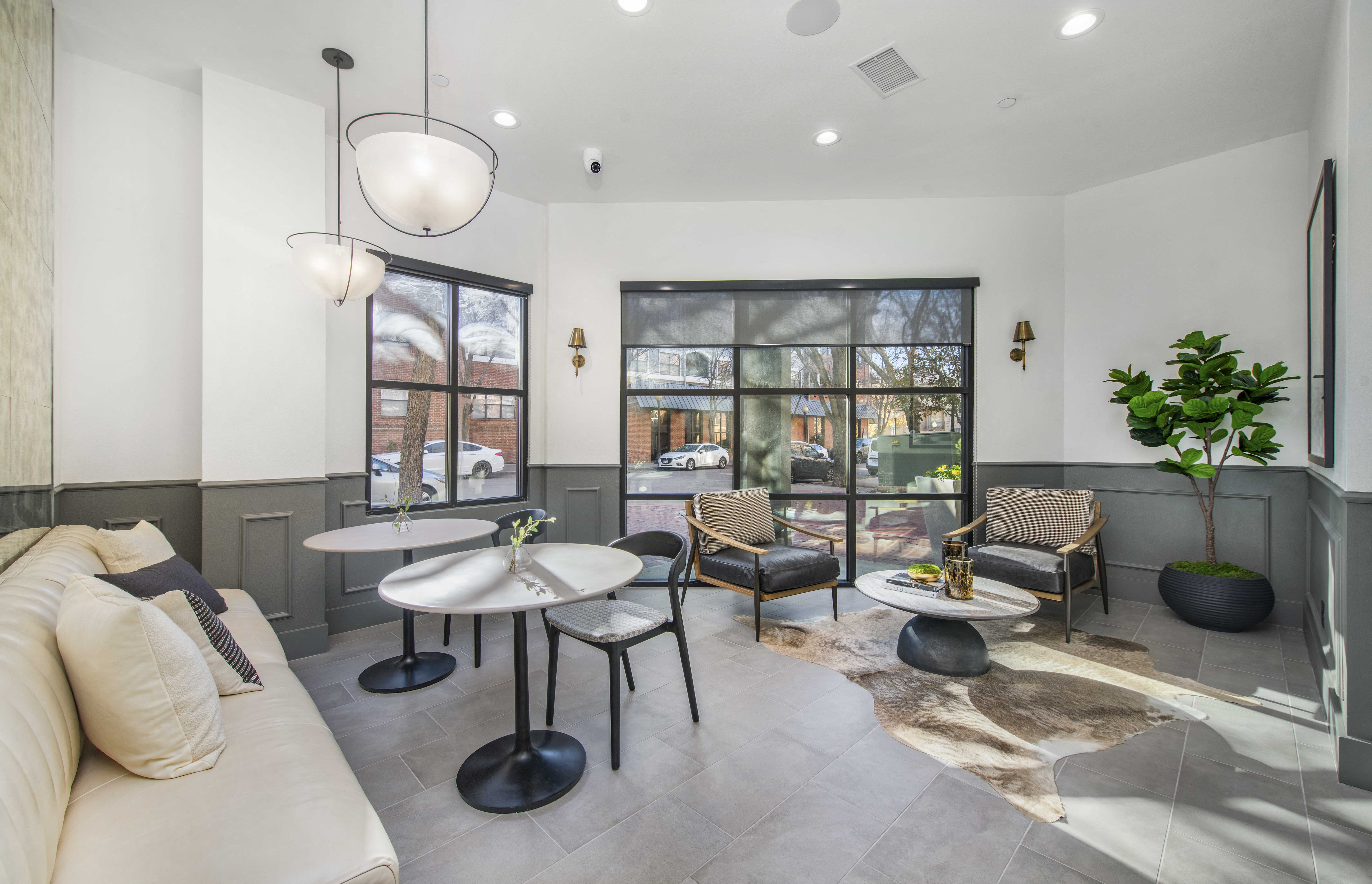 a living room with a couch and chairs and a large window