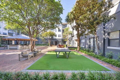 A patio with a table and chairs surrounded by trees.