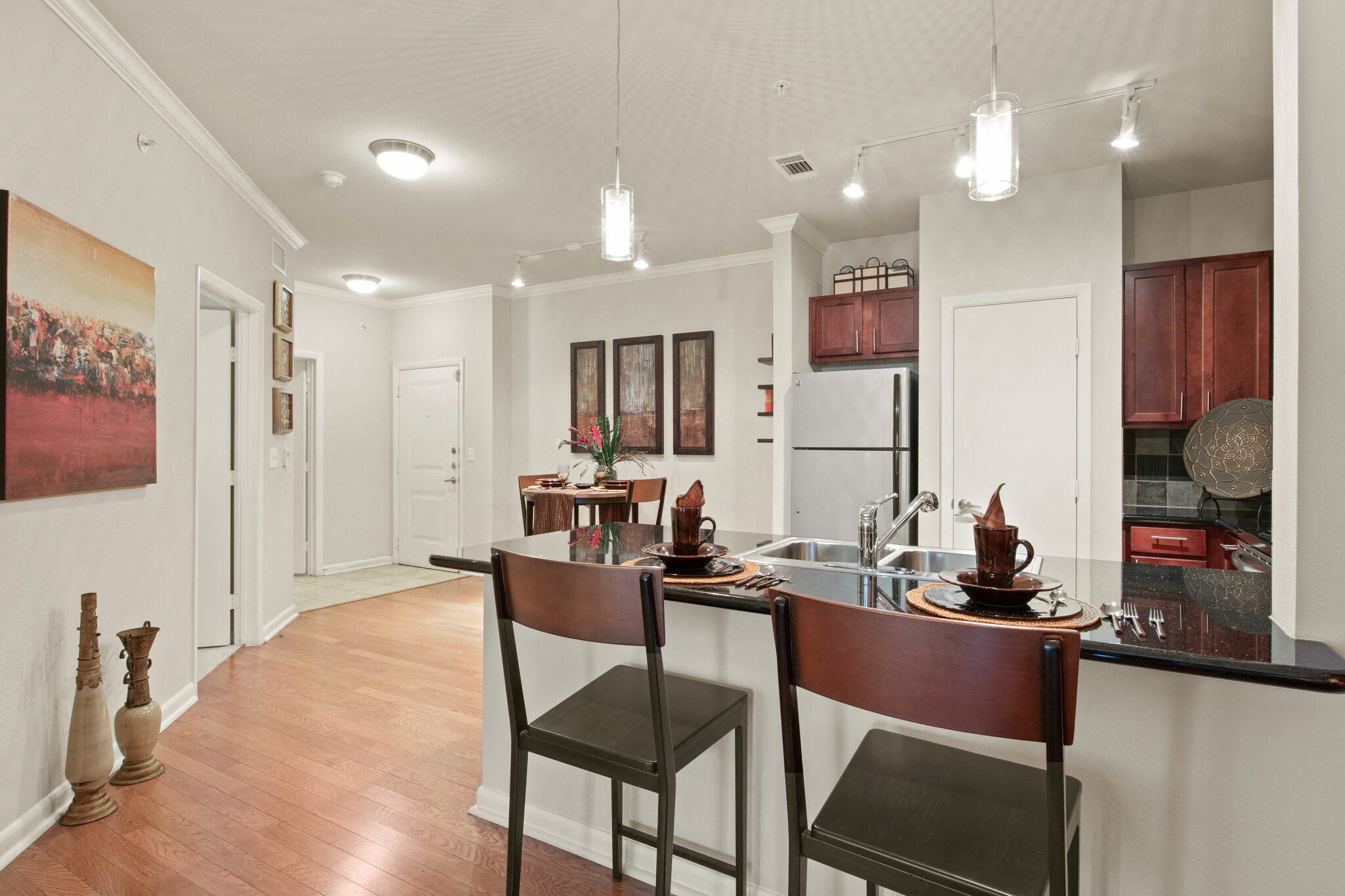an open kitchen and dining room with a bar and chairs
