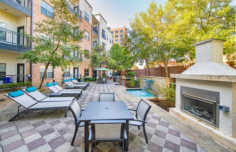 an outdoor patio with tables and chairs and a fireplace