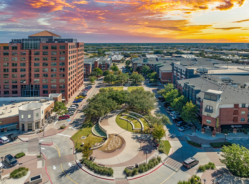 an aerial view of a city with a sunset in the background
