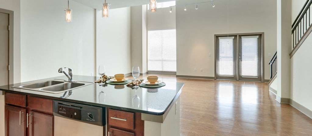 an open kitchen and living room with a large window and a sink