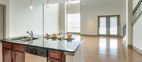 an open kitchen and living room with a large window and a sink