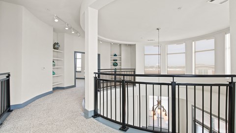 a living room with a crib and a view of a room with windows