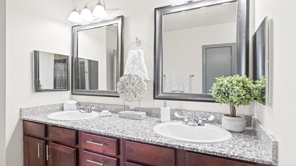 a bathroom with two sinks and two mirrors