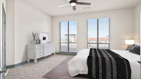 a bedroom with a bed and two windows and a ceiling fan