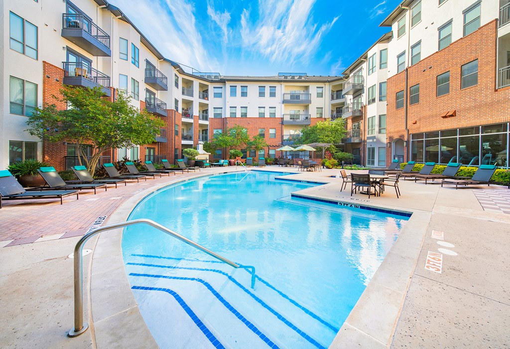 an outdoor swimming pool with an apartment building in the background