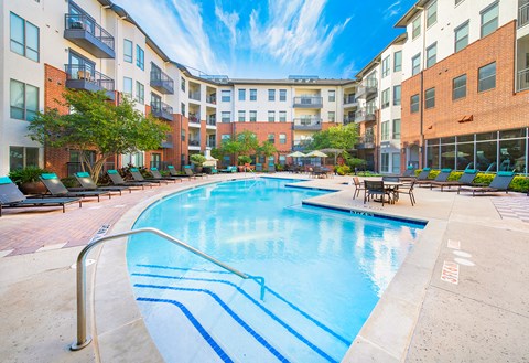 an outdoor swimming pool with an apartment building in the background