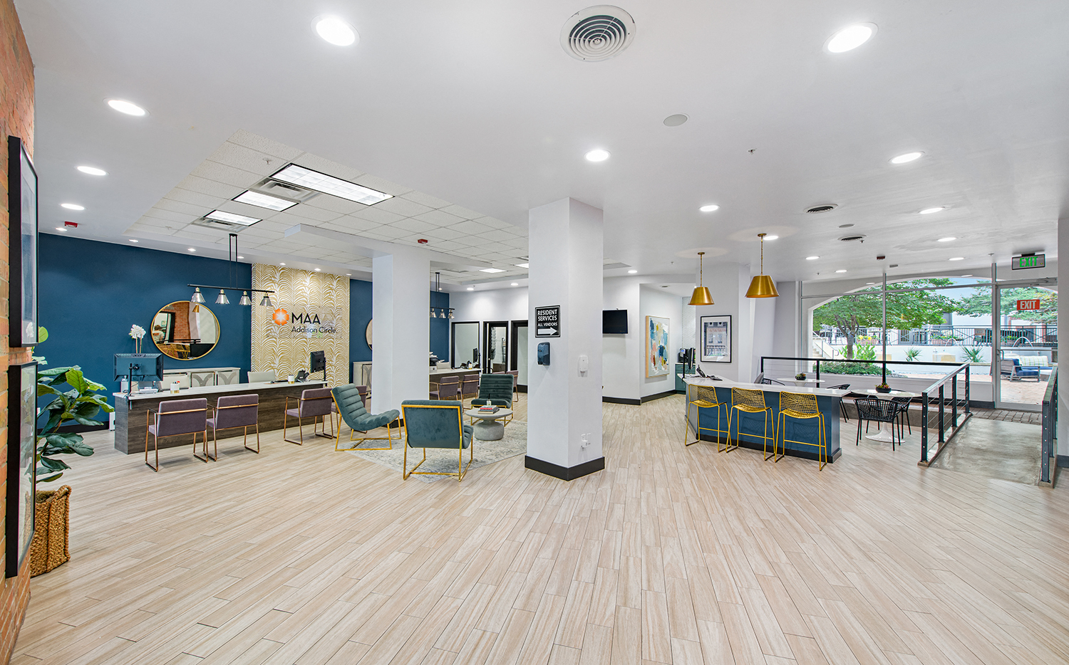 a large lobby with tables and chairs and a blue wall