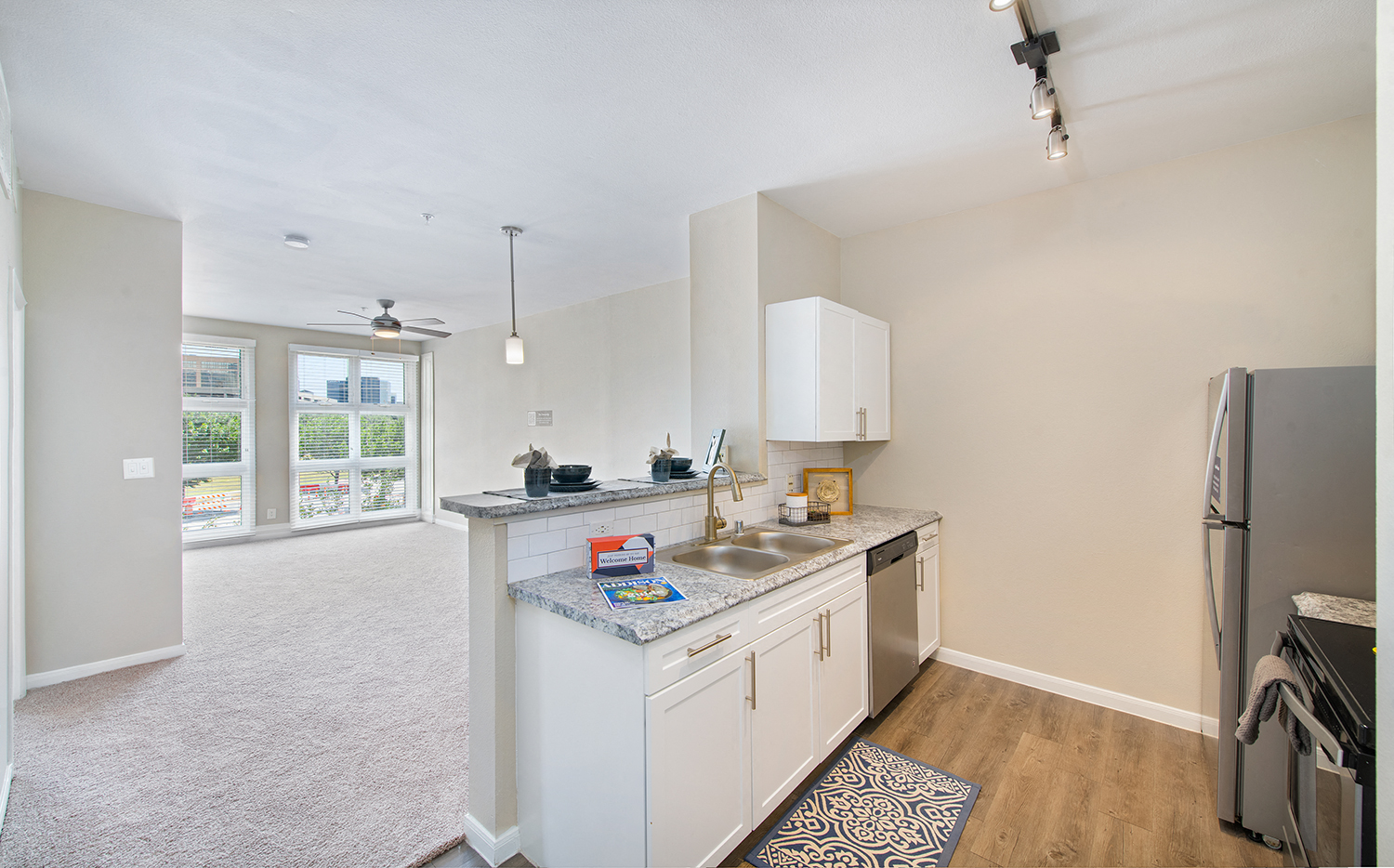 a kitchen with white cabinets and a stainless steel counter top and a large window
