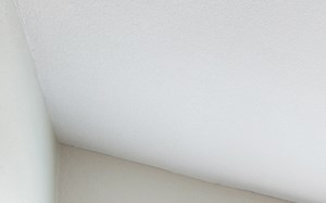 an empty living room with a ceiling fan and a window