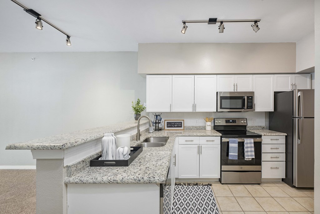 a spacious kitchen with granite counter tops and stainless steel appliances