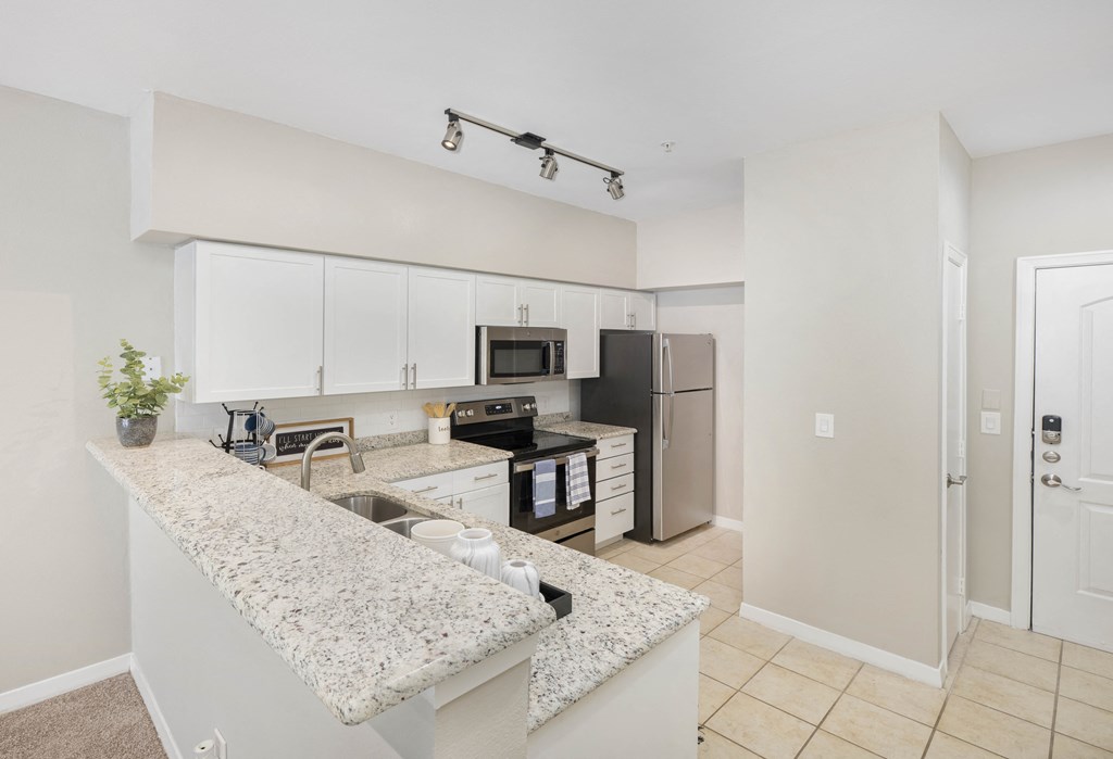a kitchen with granite counter tops and stainless steel appliances