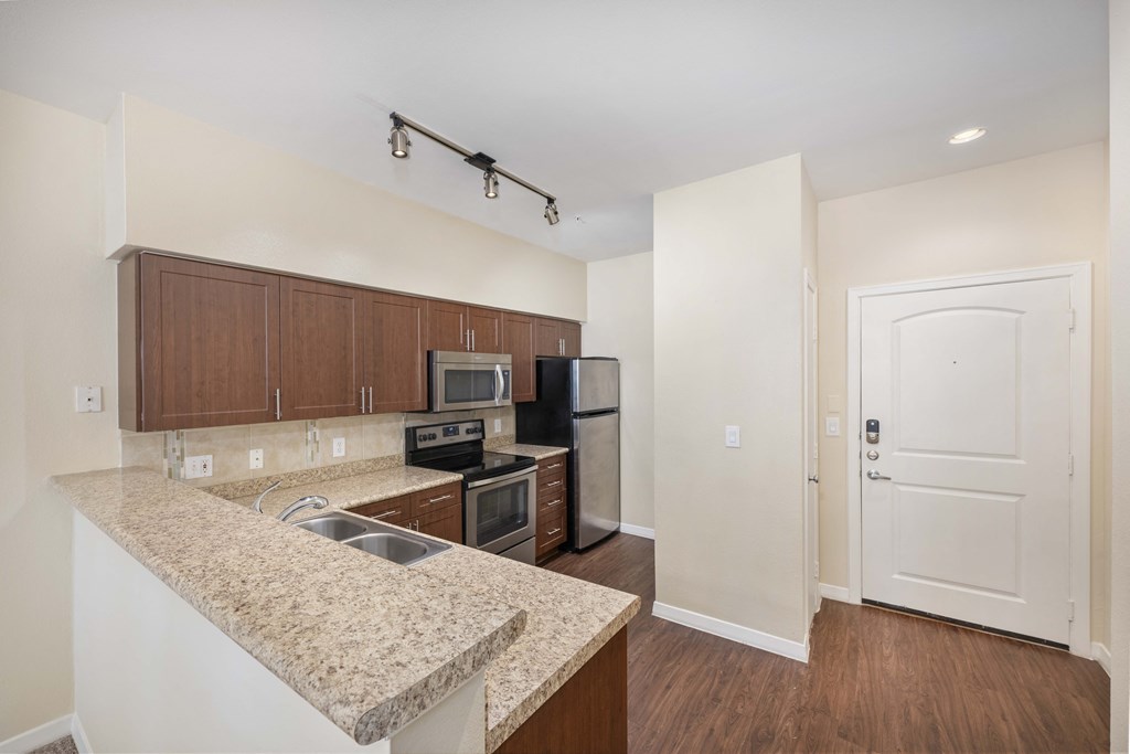 a kitchen with granite counter tops and a sink and a refrigerator
