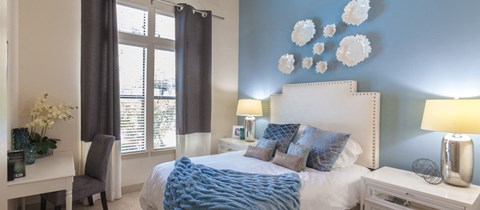 a bedroom with blue walls and a white bed