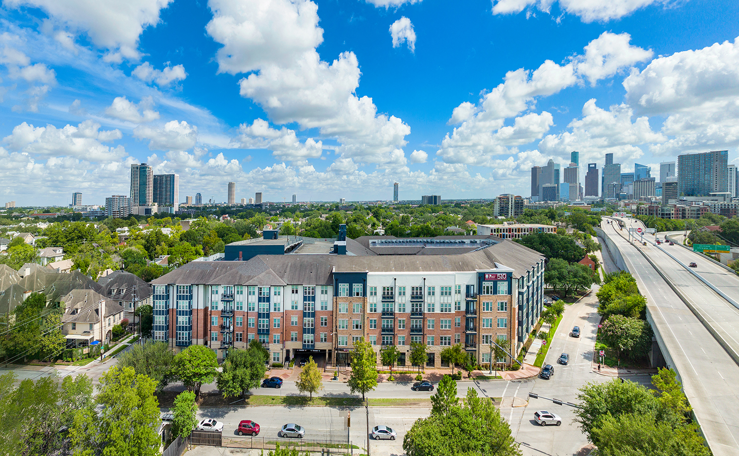 an aerial view of an apartment building with a city in the background