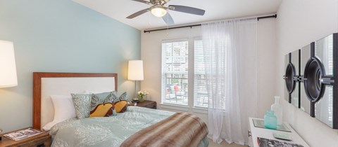 a bedroom with a large bed and a ceiling fan