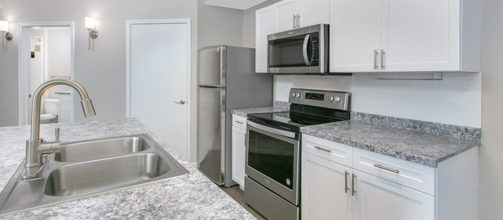 a kitchen with granite counter tops and stainless steel appliances