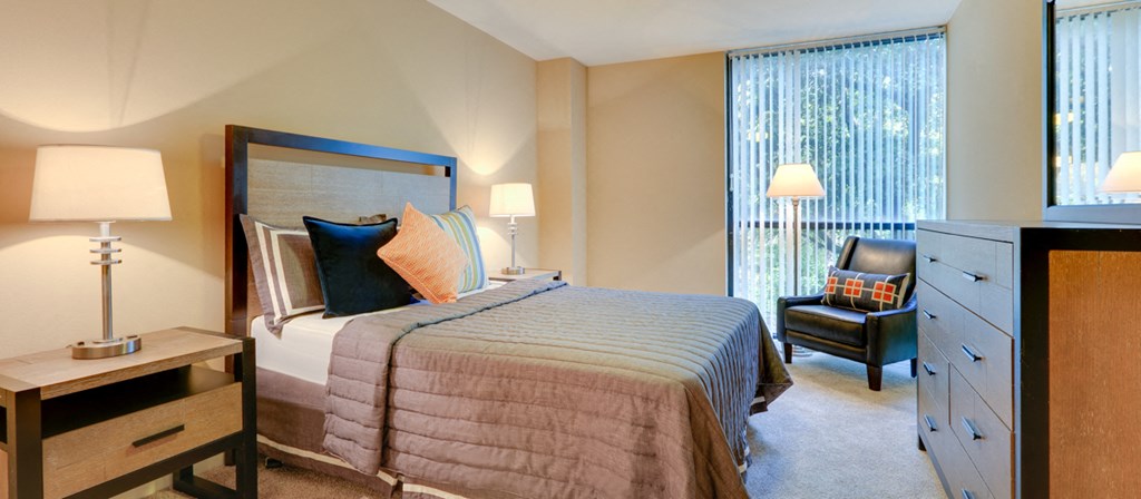 a bedroom with a bed and a dresser and a window