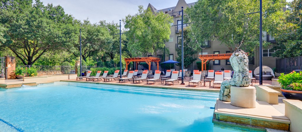 a swimming pool with lounge chairs and a statue of a fish