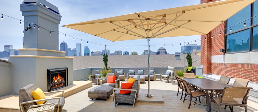 a rooftop patio with tables and chairs and a fireplace