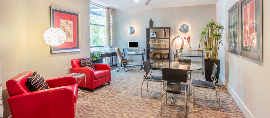 a living room and dining room with red chairs and a glass table