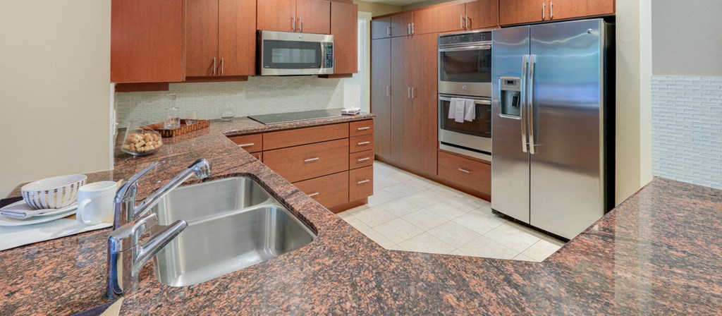 a kitchen with granite counter tops and stainless steel appliances