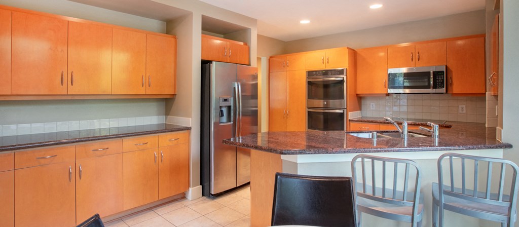 the kitchen has granite counter tops and stainless steel appliances