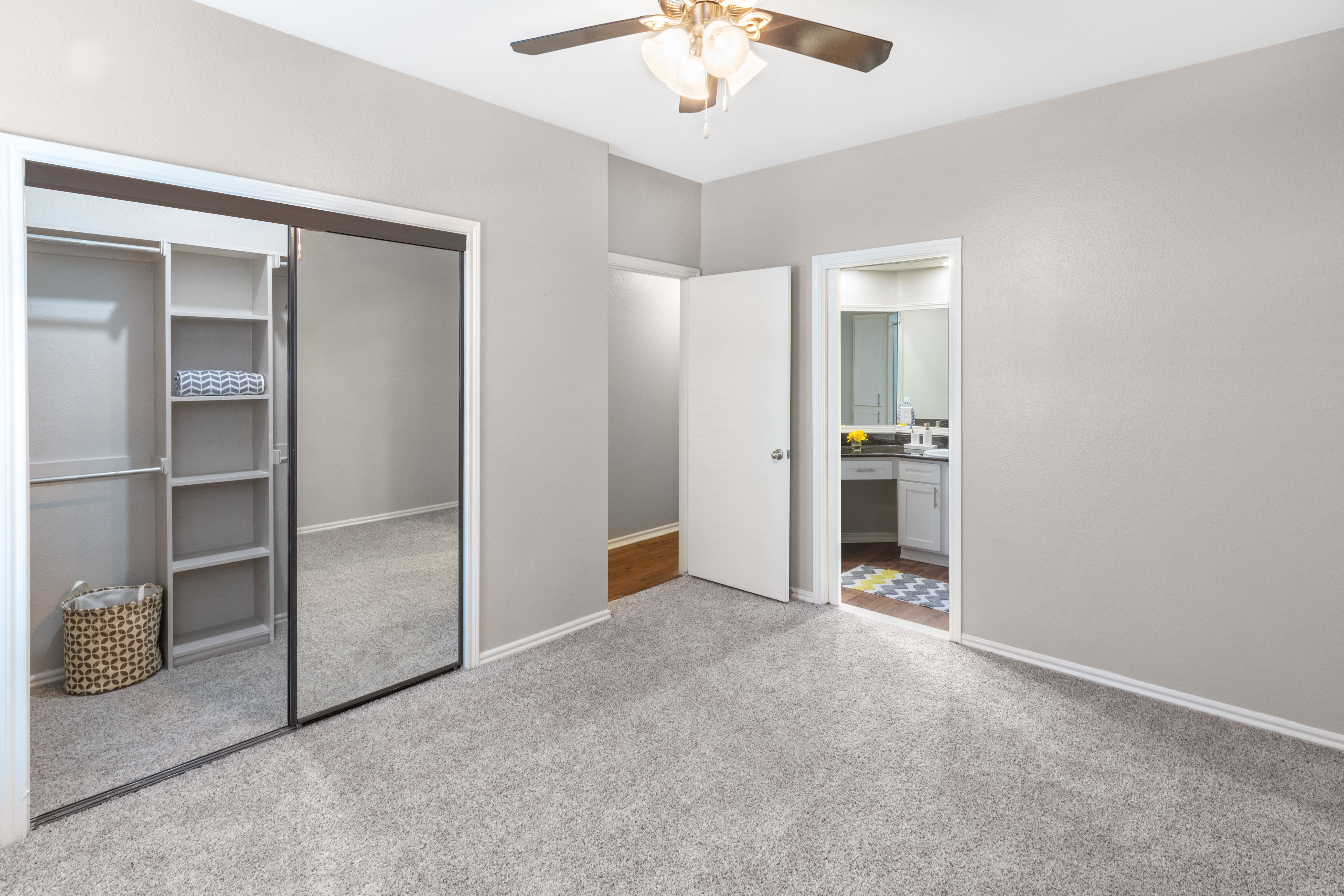 an empty room with a closet and a ceiling fan