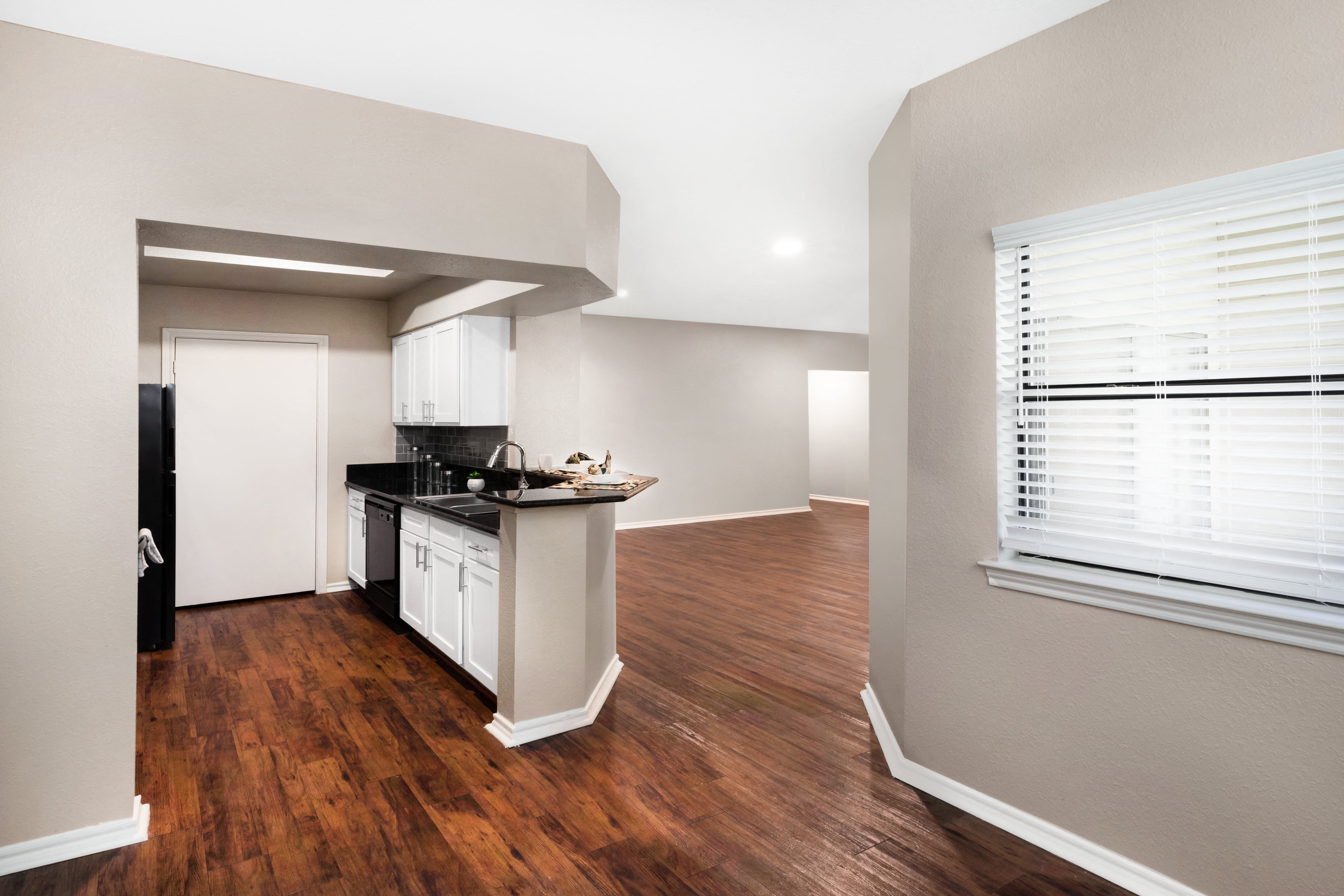 a kitchen and living room with wood floors and a window