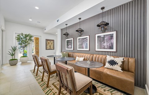A modern living room with a brown leather couch and a striped wallpaper.