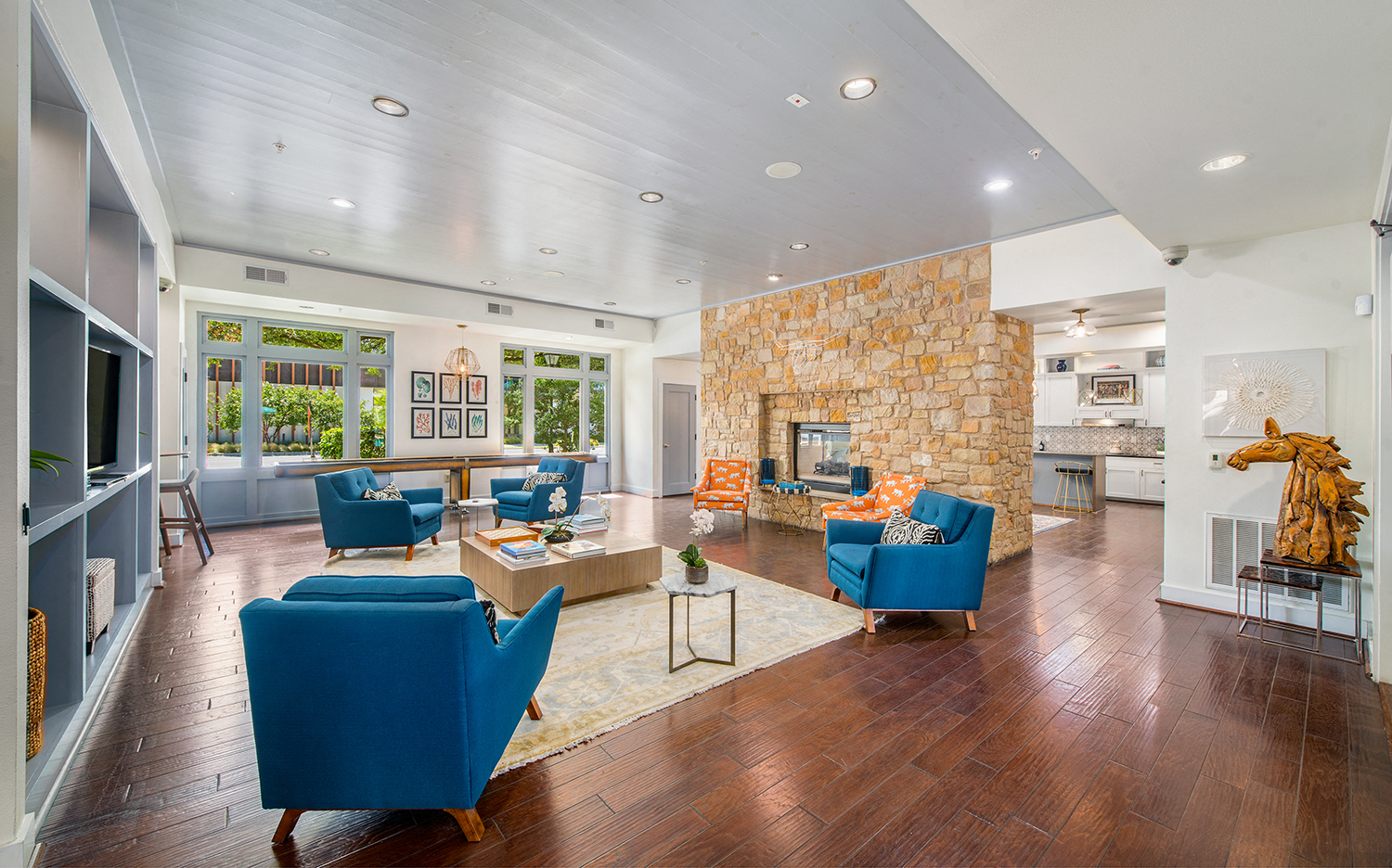 a living room with blue furniture and a stone fireplace