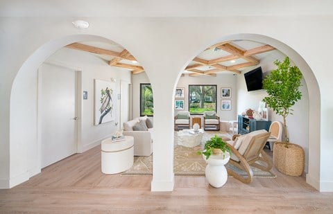 a living room with white walls and white furniture and archways
